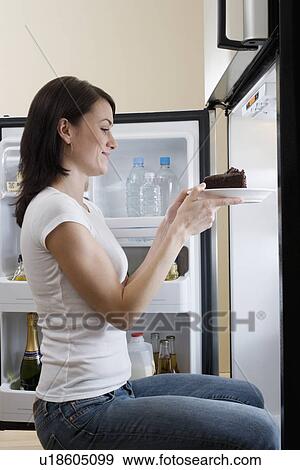 Woman taking cake out of refrigerator View Large Photo Image Stock Photo - Woman taking cake out of refrigerator. Fotosearch
