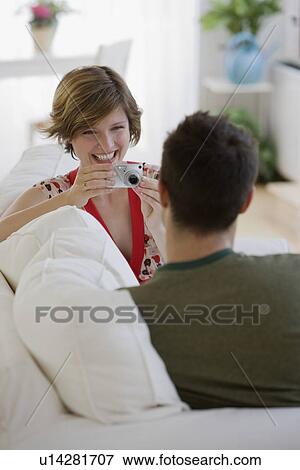 Stock Photo - Woman taking photograph of boyfriend. Fotosearch