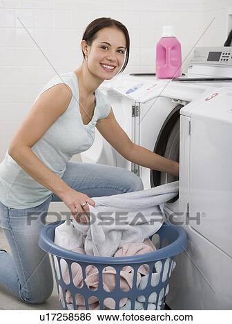 Woman talking laundry out of dryer View Large Photo Image Stock Photograph - Woman talking laundry out of dryer. Fotosearch