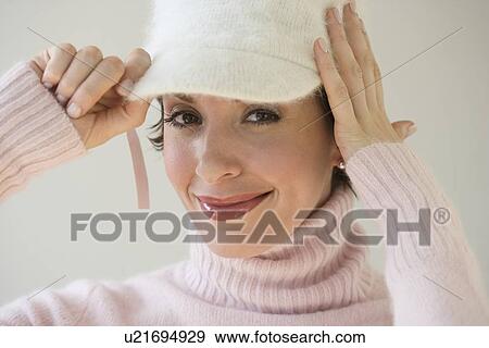 Stock Photo - Woman trying on hat. Fotosearch