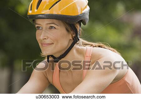 Stock Image - Woman wearing bicycle helmet. Fotosearch