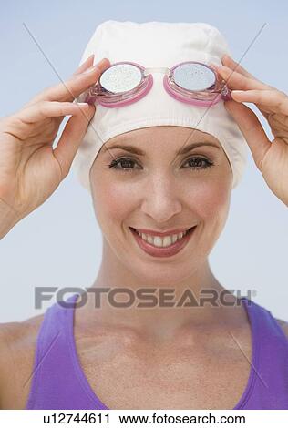 Woman wearing swimming cap and goggles View Large Photo Image Stock Image - Woman wearing swimming cap and goggles. Fotosearch
