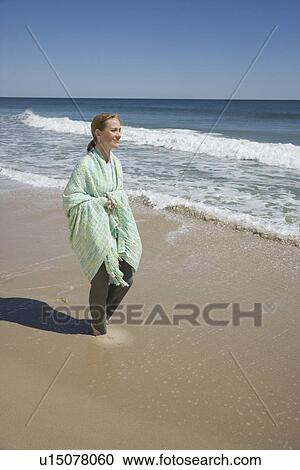 Woman wrapped in blanket at beach View Large Photo Image Stock Image - Woman wrapped in blanket at beach. Fotosearch