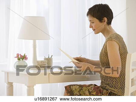 Stock Photo - Woman writing letter at desk. Fotosearch