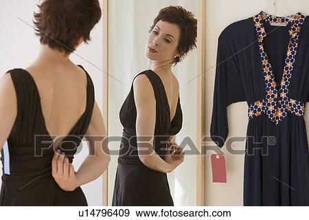 Stock Photo - Woman zipping back of dress. Fotosearch