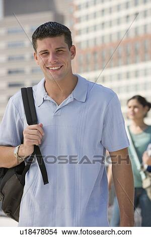 Picture - Young man carrying backpack. Fotosearch