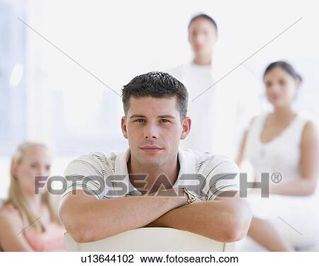 Stock Image - Young man in front of friends. Fotosearch