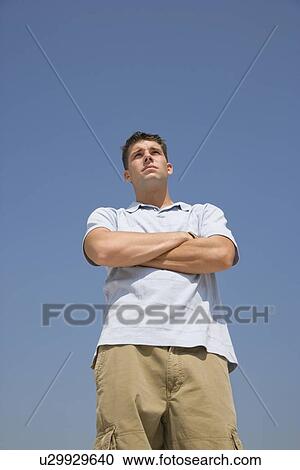 Stock Image - Young man with arms crossed. Fotosearch
