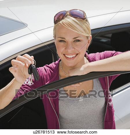 Stock Image - Young woman holding keys to new car. Fotosearch