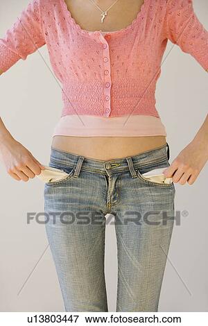 Stock Photo - Young woman pulling out pockets. Fotosearch