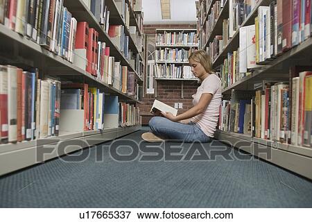 Young woman reading in library View Large Photo Image Stock Photo - Young woman reading in library. Fotosearch