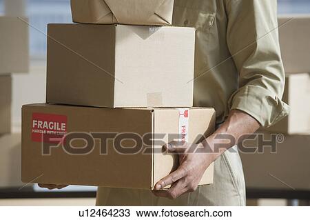 African delivery man carrying stack of packages View Large Photo Image Stock Image - African delivery man carrying stack of packages. Fotosearch