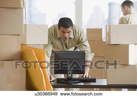 African delivery man looking at computer View Large Photo Image Stock Photo - African delivery man looking at computer. Fotosearch