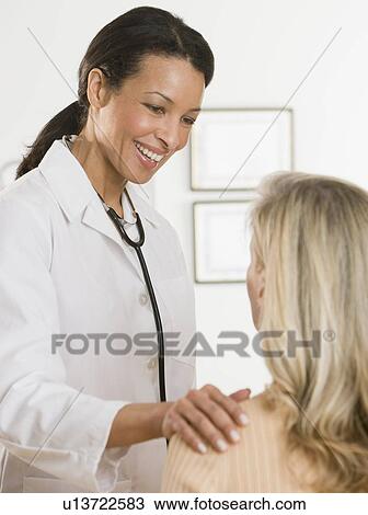 Stock Image - African female doctor reassuring patient. Fotosearch