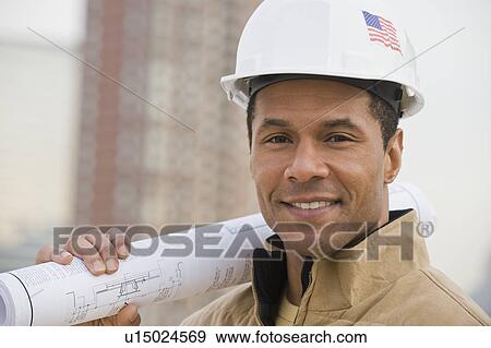 African male construction worker holding blueprints View Large Photo Image Stock Photo - African male construction worker holding blueprints. Fotosearch