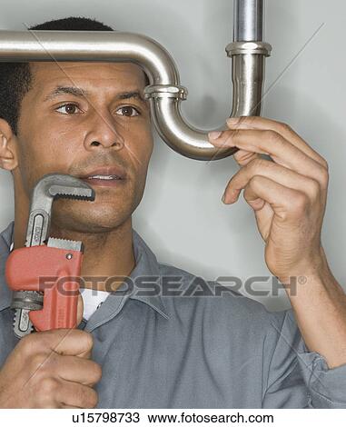 African male plumber holding wrench next to pipe View Large Photo Image Stock Image - African male plumber holding wrench next to pipe. Fotosearch