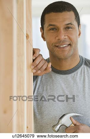 Stock Photo - African man holding hammer. Fotosearch