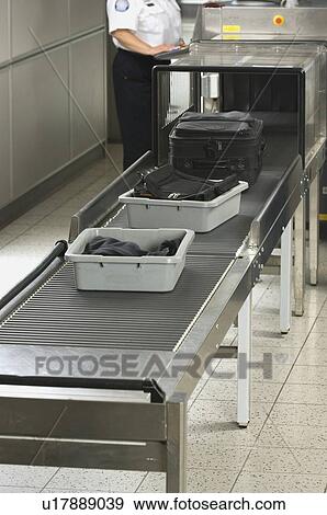 Stock Photo - Airport security worker checking baggage. Fotosearch