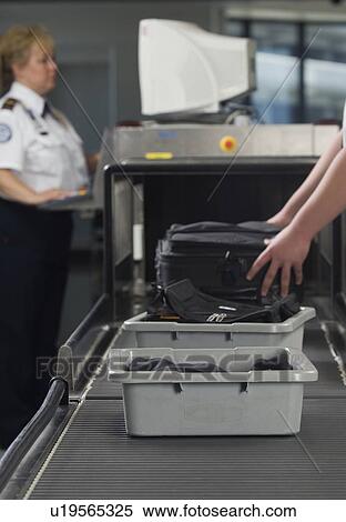 Stock Photography - Airport security worker checking baggage. Fotosearch