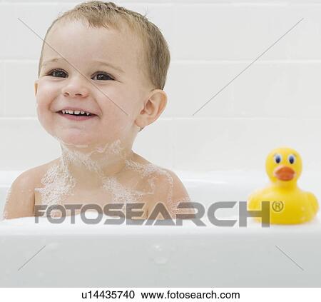 Stock Image - Baby and rubber duck in bath. Fotosearch