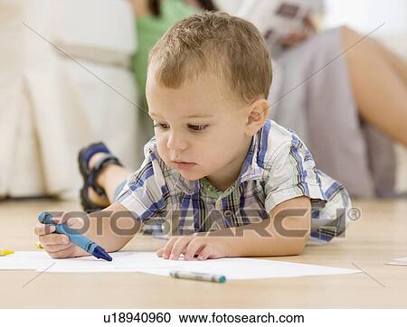Stock Image - Baby coloring on floor. Fotosearch