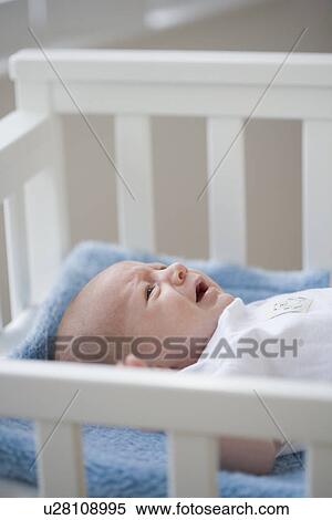 Stock Photography - Baby crying in crib. Fotosearch