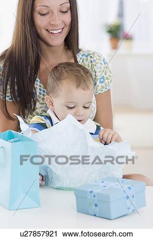 Stock Image - Baby opening gifts. Fotosearch