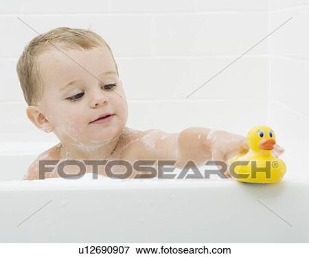 Baby playing with rubber duck in bath View Large Photo Image Stock Photo - Baby playing with rubber duck in bath. Fotosearch