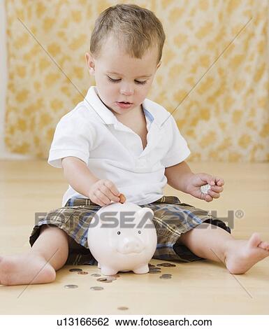 Baby putting coins in piggy bank View Large Photo Image Stock Image - Baby putting coins in piggy bank. Fotosearch