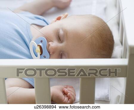 Baby sleeping in crib View Large Photo Image Picture - Baby sleeping in crib. Fotosearch