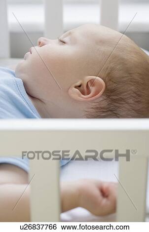 Baby sleeping in crib View Large Photo Image Stock Photograph - Baby sleeping in crib. Fotosearch