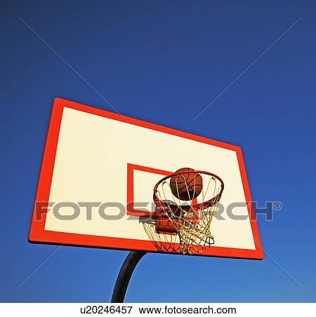 Basketball in mid air over hoop View Large Photo Image Stock Photo - Basketball in mid air over hoop. Fotosearch