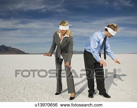 Stock Photograph - Blindfolded businesspeople on salt flats, Salt Flats, Utah, United States. Fotosearch