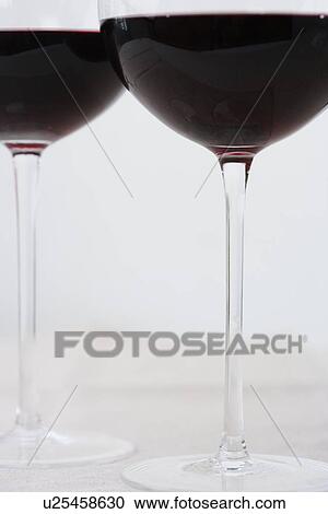 Stock Image - Bottom of wineglasses with red wine. Fotosearch