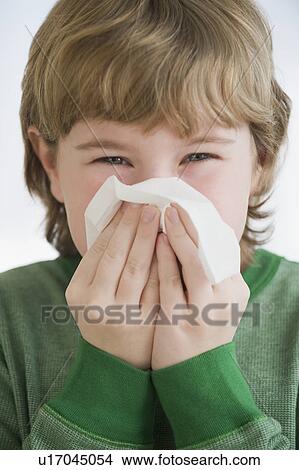 Picture - Boy blowing nose. Fotosearch