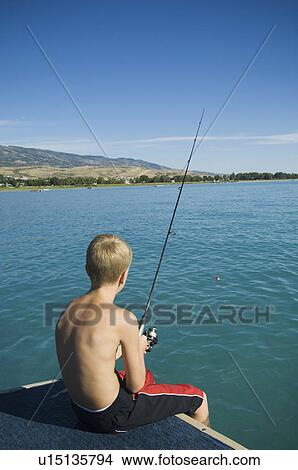 Boy fishing off dock in lake, Utah, United States View Large Photo Image Picture - Boy fishing off dock in lake, Utah, United States. Fotosearch