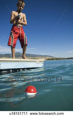 Boy fishing off dock in lake, Utah, United States View Large Photo Image Stock Image - Boy fishing off dock in lake, Utah, United States. Fotosearch