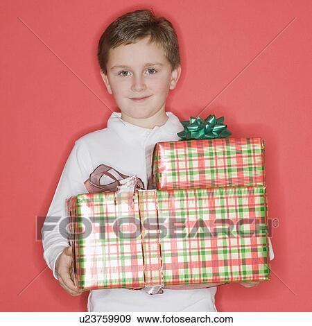 Boy holding stack of gifts View Large Photo Image Stock Photo - Boy holding stack of gifts. Fotosearch