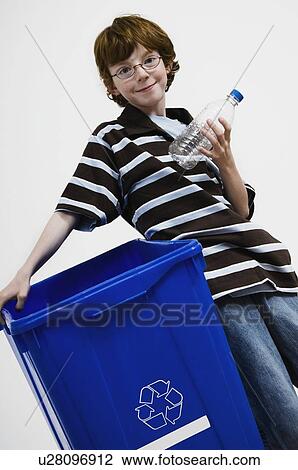 Stock Image - Boy leaning on recycling bin. Fotosearch