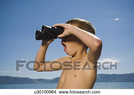 Boy looking through binoculars, Utah, United States View Large Photo Image Picture - Boy looking through binoculars, Utah, United States. Fotosearch