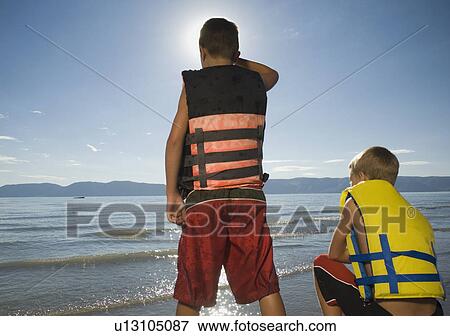 Boys in life jackets looking out over lake, Utah, United States View Large Photo Image Stock Photo - Boys in life jackets looking out over lake, Utah, United States. Fotosearch
