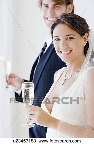 Stock Photo - Bride and groom holding champagne glasses. Fotosearch