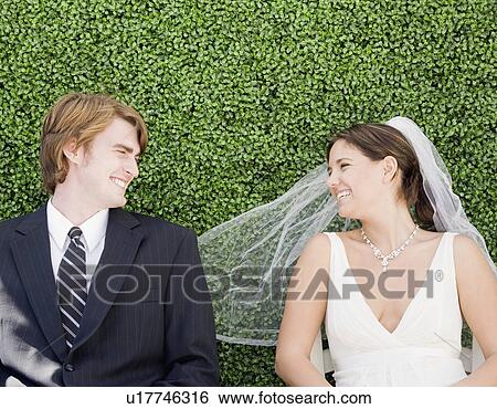 Bride and groom laying in grass View Large Photo Image Stock Photograph - Bride and groom laying in grass. Fotosearch
