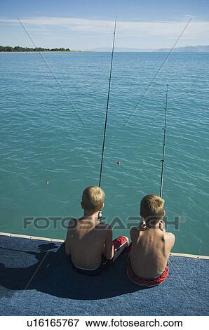 Brothers fishing off dock in lake, Utah, United States View Large Photo Image Stock Photo - Brothers fishing off dock in lake, Utah, United States. Fotosearch