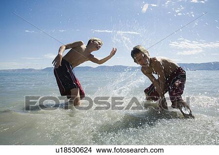 Brothers splashing in lake, Utah, United States View Large Photo Image Picture - Brothers splashing in lake, Utah, United States. Fotosearch