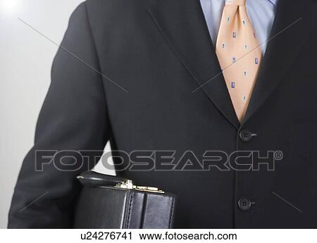 Stock Image - Businessman carrying a briefcase. Fotosearch