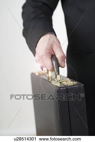 Stock Image - Businessman carrying a briefcase. Fotosearch