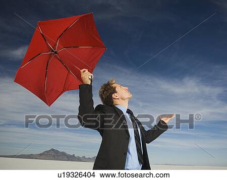 Picture - Businessman holding umbrella, Salt Flats, Utah, United States. Fotosearch