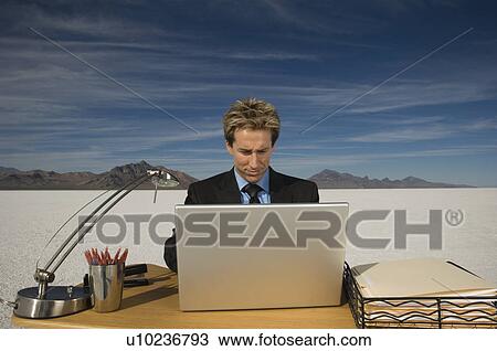 Businessman on salt flats looking at laptop, Salt Flats, Utah, United States View Large Photo Image Stock Image - Businessman on salt flats looking at laptop, Salt Flats, Utah, United States. Fotosearch