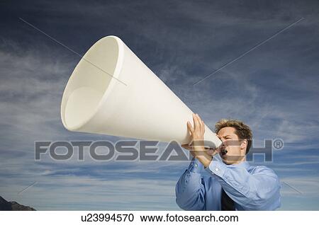 Stock Image - Businessman yelling into megaphone, Salt Flats, Utah, United States. Fotosearch